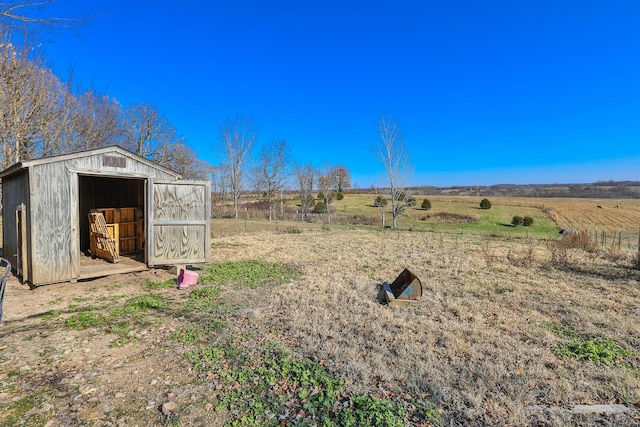 view of yard with a rural view and a shed