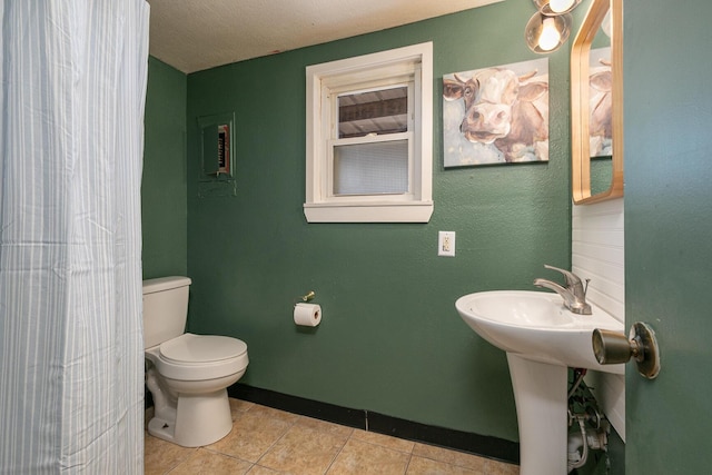 bathroom with tile patterned flooring, a textured ceiling, and toilet