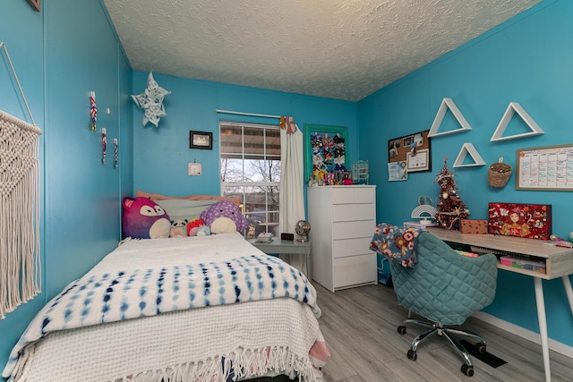 bedroom with a textured ceiling and light wood-type flooring