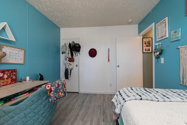 bedroom with a textured ceiling and hardwood / wood-style flooring