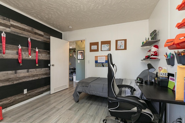 home office featuring wood-type flooring and a textured ceiling