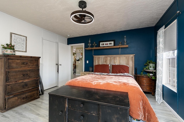 bedroom featuring a textured ceiling and light hardwood / wood-style flooring