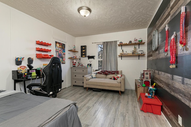 bedroom featuring a textured ceiling and light hardwood / wood-style flooring