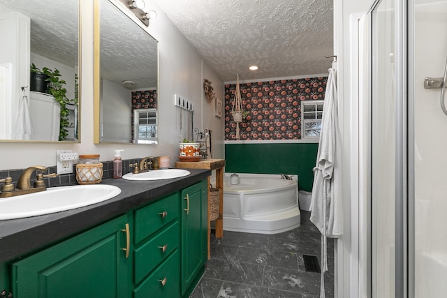 bathroom with tile patterned floors, a bathtub, a textured ceiling, and vanity