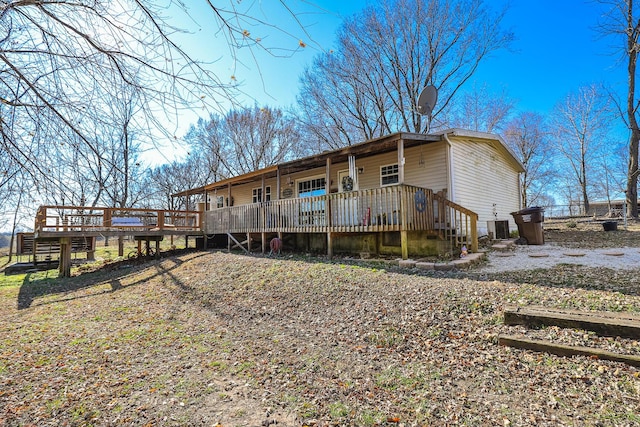 rear view of house featuring a wooden deck