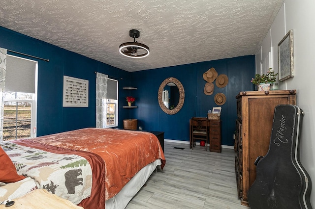 bedroom featuring light wood-type flooring and a textured ceiling