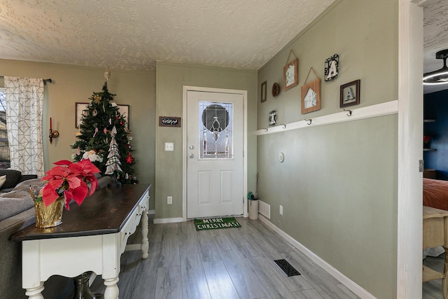 foyer featuring wood-type flooring and a textured ceiling