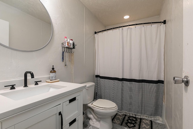 bathroom featuring vanity, a textured ceiling, and toilet