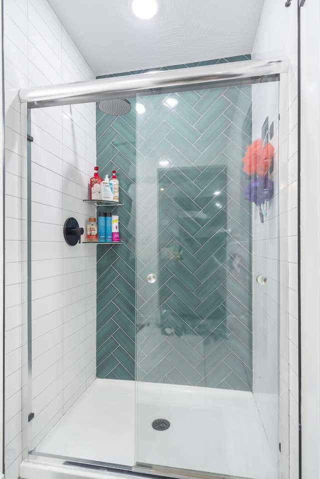 bathroom featuring a shower with door