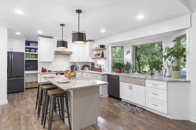 kitchen featuring white cabinetry, dark hardwood / wood-style flooring, a center island, and stainless steel appliances