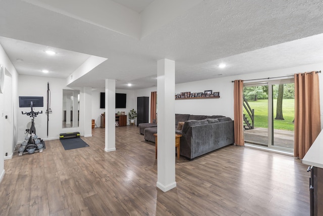 exercise room featuring wood-type flooring and a textured ceiling