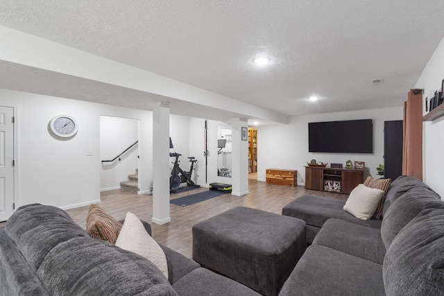 living room featuring wood-type flooring and a textured ceiling