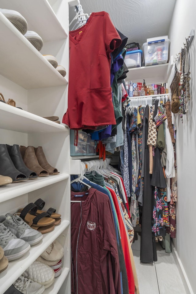 walk in closet with light tile patterned floors