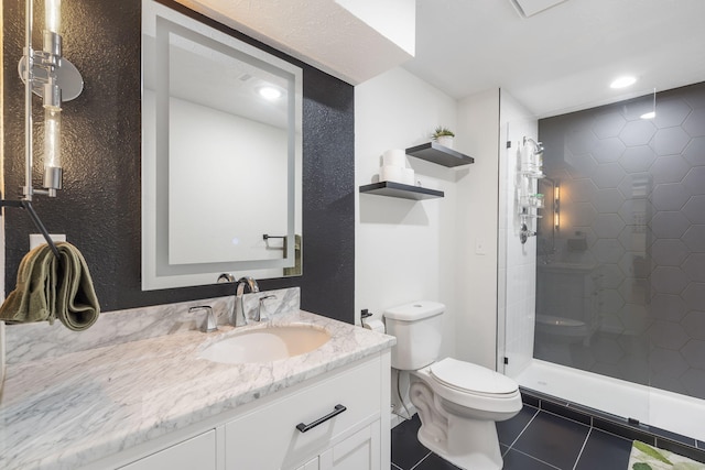 bathroom featuring tile patterned flooring, vanity, tiled shower, and toilet