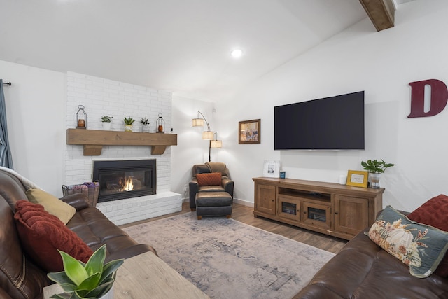 living room with a fireplace, lofted ceiling with beams, and hardwood / wood-style flooring