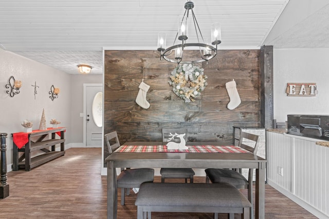 dining area with wood-type flooring, vaulted ceiling, and an inviting chandelier