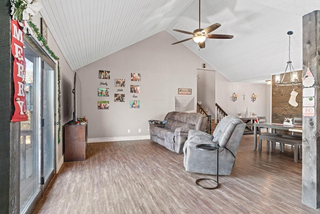 living room featuring hardwood / wood-style floors, ceiling fan with notable chandelier, and lofted ceiling