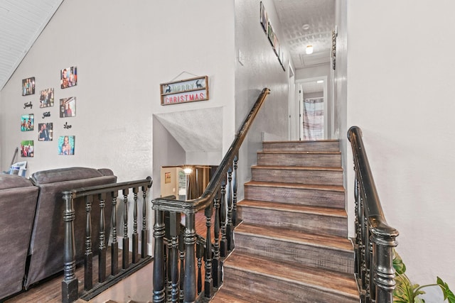 staircase with hardwood / wood-style flooring and vaulted ceiling