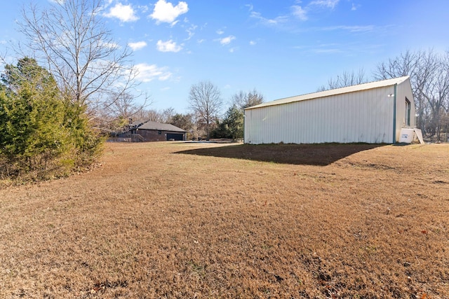 view of home's exterior with a lawn and an outdoor structure