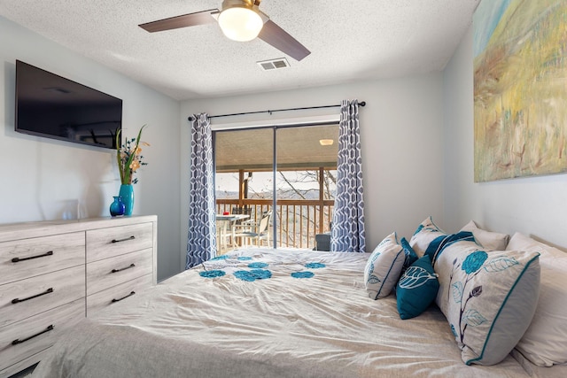 bedroom featuring access to exterior, a textured ceiling, and ceiling fan