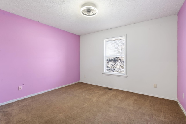 unfurnished room featuring carpet and a textured ceiling