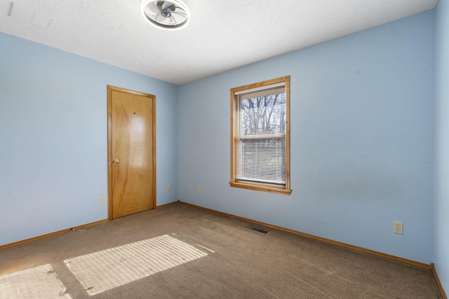 spare room featuring carpet flooring and a textured ceiling