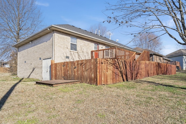 view of side of property featuring a lawn and a wooden deck