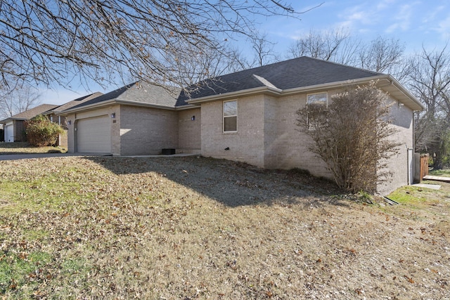 view of side of property featuring a lawn and a garage