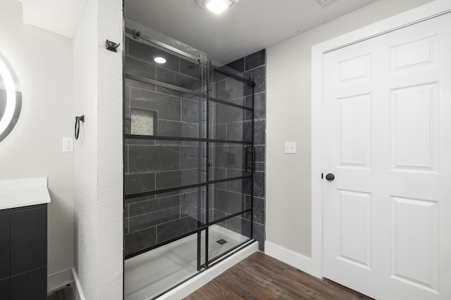 bathroom featuring wood-type flooring and tiled shower