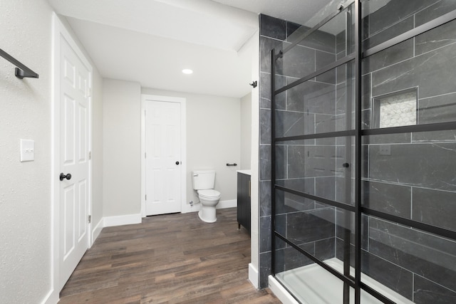 bathroom featuring walk in shower, toilet, vanity, and hardwood / wood-style flooring