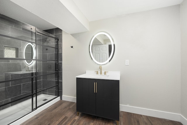 bathroom featuring vanity, wood-type flooring, and walk in shower