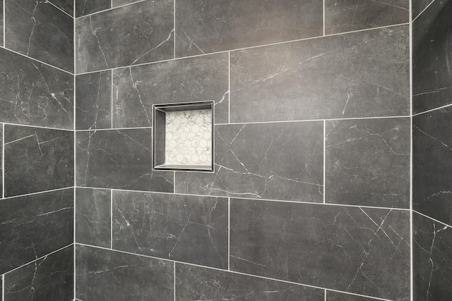 interior details with a tile shower