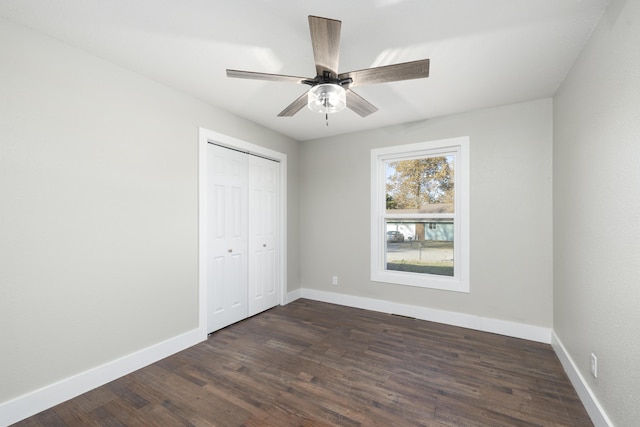 unfurnished bedroom featuring a closet, ceiling fan, and dark wood-type flooring