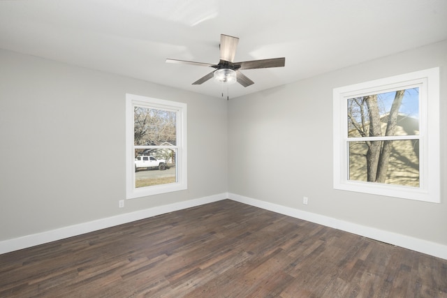 spare room featuring plenty of natural light, ceiling fan, and dark hardwood / wood-style flooring