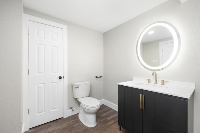 bathroom with vanity, toilet, and wood-type flooring