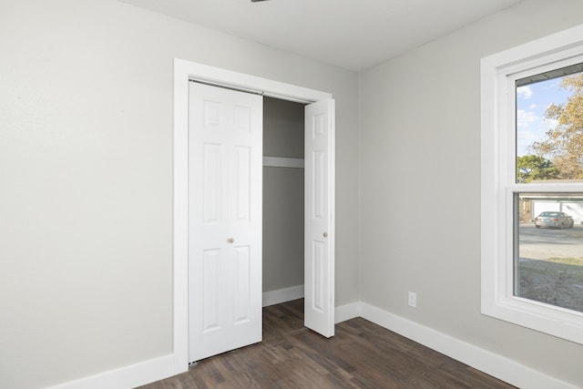 unfurnished bedroom featuring dark hardwood / wood-style flooring and a closet