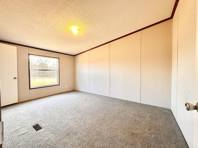 unfurnished room with carpet flooring, ornamental molding, and a textured ceiling