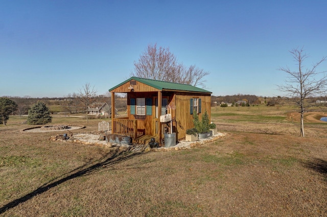 view of outdoor structure featuring a rural view and a lawn