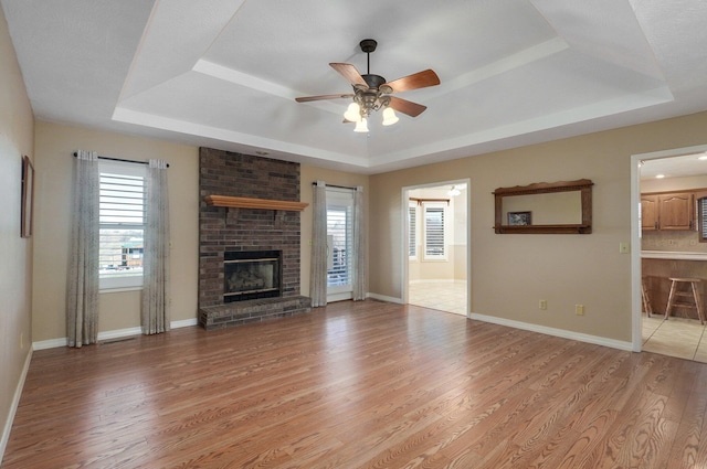 10071 W Farm Road 48, Walnut Grove, MO 65770 - unfurnished living room featuring a tray ceiling, ceiling fan, and light wood finished floors