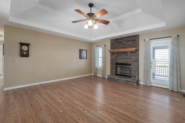 unfurnished living room featuring a raised ceiling and wood-type flooring