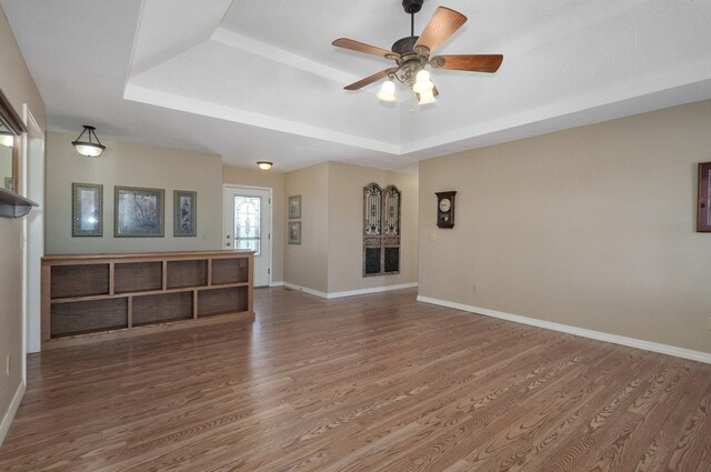 10071 W Farm Road 48, Walnut Grove, MO 65770 - unfurnished living room with a tray ceiling, wood finished floors, and ceiling fan