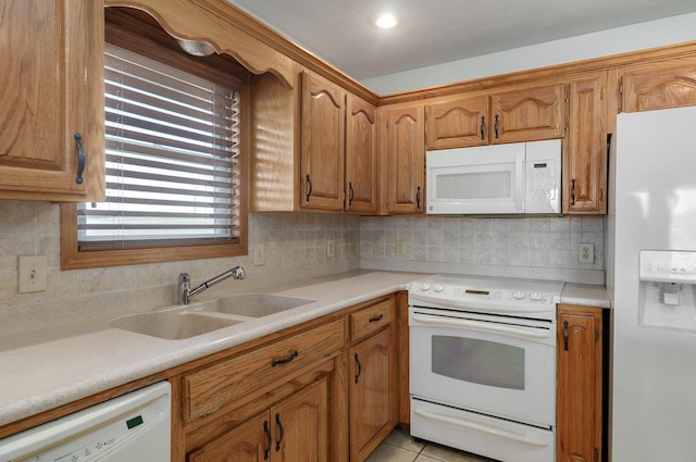 kitchen with light tile patterned flooring, white appliances, backsplash, and sink