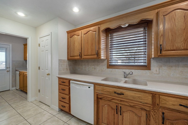 kitchen with decorative backsplash, dishwasher, light tile patterned floors, and sink