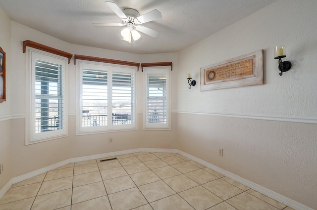 unfurnished room with light tile patterned floors and ceiling fan