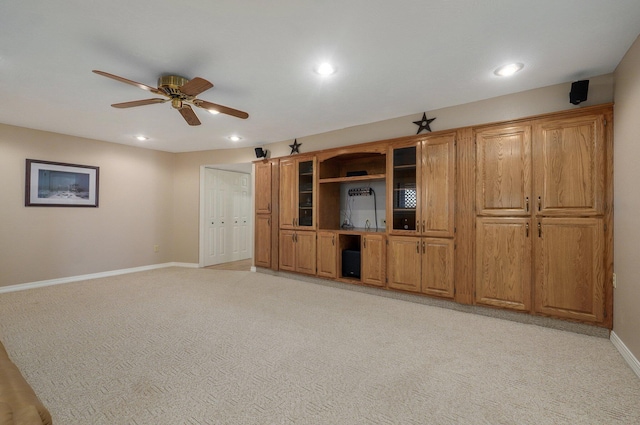 unfurnished living room featuring ceiling fan and light carpet