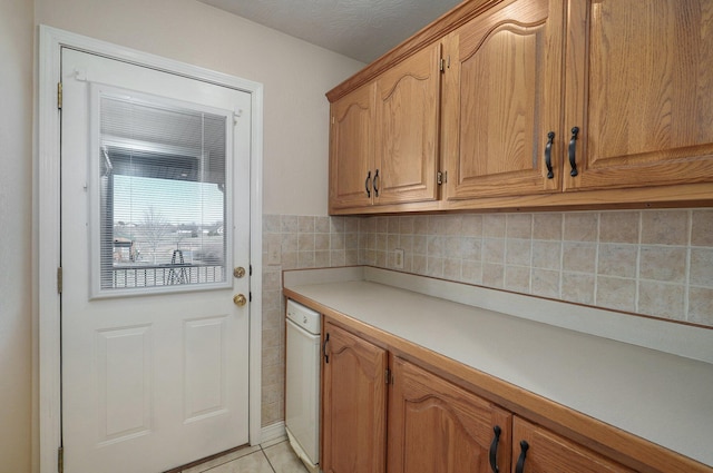 kitchen with dishwasher, light tile patterned floors, and a textured ceiling