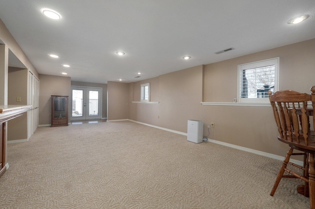 basement featuring light carpet and french doors