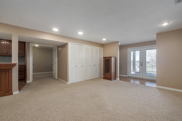 unfurnished bedroom featuring access to exterior, light colored carpet, and french doors