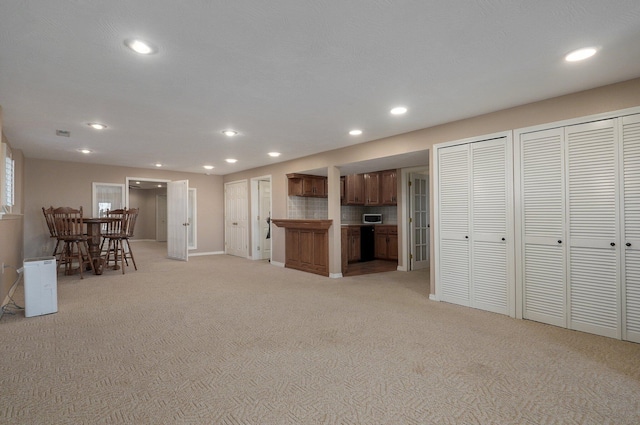 10071 W Farm Road 48, Walnut Grove, MO 65770 - kitchen with light carpet, recessed lighting, brown cabinets, stainless steel microwave, and light countertops