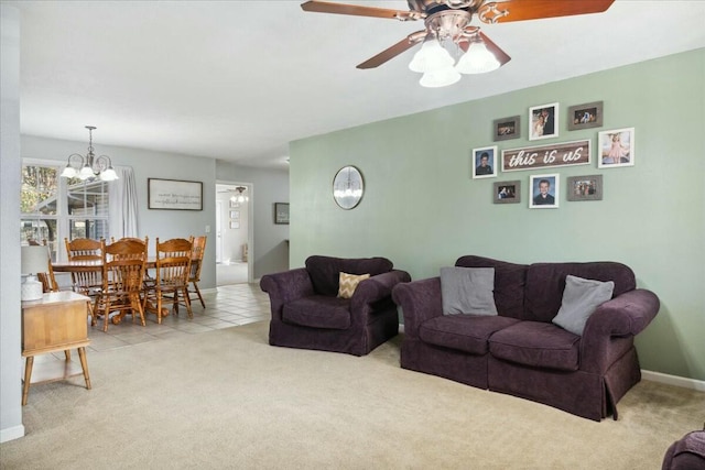 carpeted living room featuring ceiling fan with notable chandelier